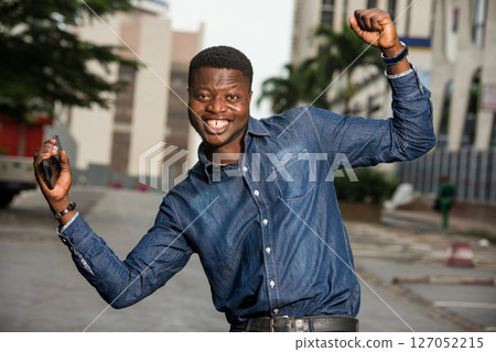 portrait of young african man with mobile phone, happy. 127052215