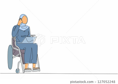 Single one line drawing Arab woman in wheelchair having phone conversation while working online on laptop. Disability businesswoman talking with client on mobile phone. Continuous line design graphic 127052248