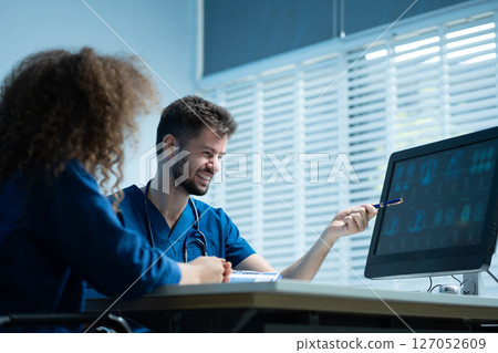 male doctor explaining to patient results of model brain. Diagnosis of diseases and head injuries. 127052609