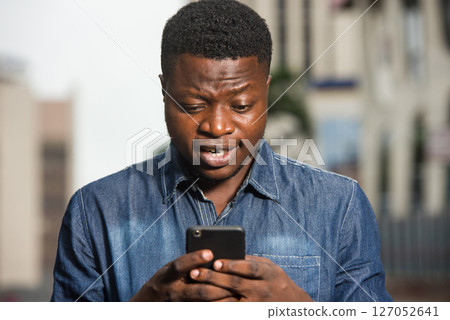close-up of young man with mobile phone, happy. close-up of young man with mobile phone, happy. 127052641