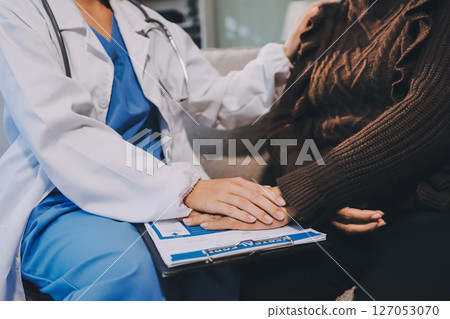 Doctor came to check the patient and shook his hand to encourage. Comforting the sick and treating the best, cured in the hospital. 127053070