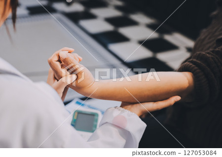 Orthopaedic doctor doing physical examination patient with wrist pain at the clinic. Physical therapist checks the patient wrist by pressing the wrist bone. Orthopaedic doctor doing physical examination patient with wrist pain at the clinic. Physical therapist checks the patient wrist by pressing the wrist bone. 127053084