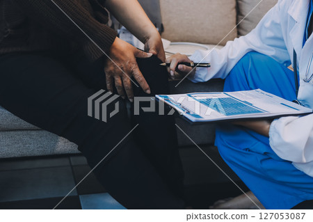Young doctor examines senior patient's leg Young doctor examines senior patient's leg 127053087