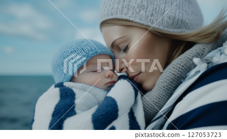 Newborn baby sleeping in mothers arms, both wrapped in blankets 127053723