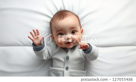 cute baby lying on a white blanket with raised arms. Adorable cartoon newborn, top view 127055486