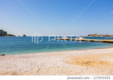 ier and boats near coastal town. Seaside tourism, marine transport, and scenic view of Budva in Montenegro. 127055505