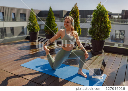 Engaging in Yoga Practice on a Rooftop Space Filled with Invigorating Natural Light 127056016