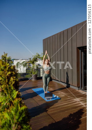 Engaging in a Revitalizing Yoga Practice on a Rooftop with a Beautiful Scenic View 127056115
