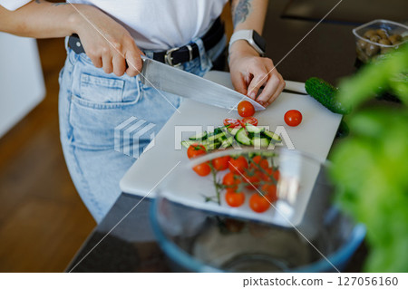 Fresh Ingredients are Being Expertly Chopped in a Sleek and Modern Kitchen Setting 127056160