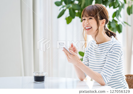 A woman operating a smartphone. 127056329