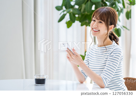 A woman operating a smartphone. 127056330