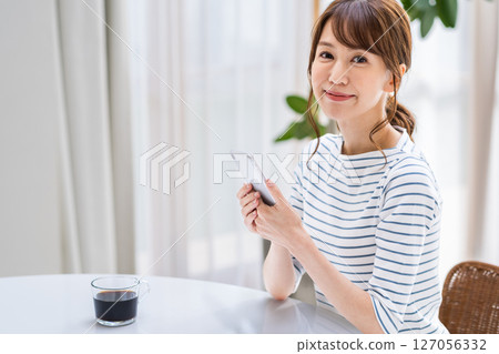 A woman operating a smartphone. 127056332