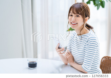 A woman operating a smartphone. 127056333