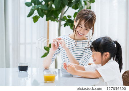 父母和孩子在客廳一起看平板電腦 127056800