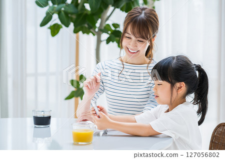 父母和孩子在客廳一起看平板電腦 127056802