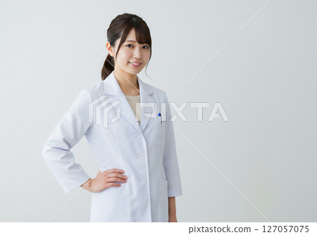 Portrait of a young female researcher wearing a white coat 127057075