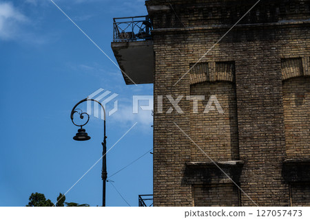 The facade of an old brick building in Batumi, Georgia. Street lamp on the left The facade of an old brick building in Batumi, Georgia. Street lamp on the left 127057473