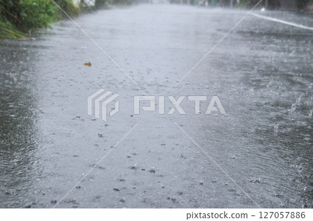 大雨期間,雨水漣漪衝擊路上的水坑 大雨期間,雨水漣漪衝擊路上的水坑 127057886