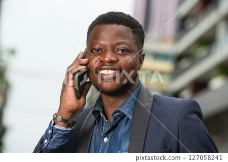 Attractive young businessman using a mobile phone outside 127058241