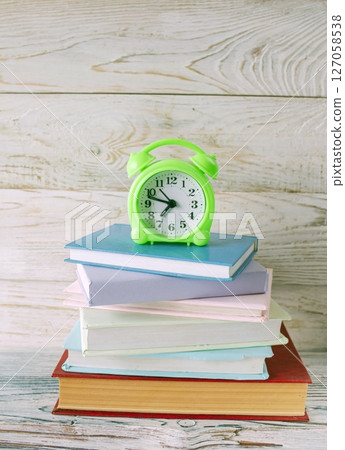 Alarm clock and stack of books on wooden background. Back to school concept. 127058538