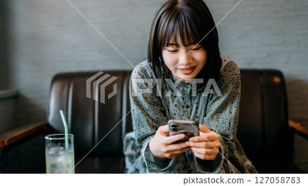 坐在沙發上使用智能手機的年輕女子 127058783