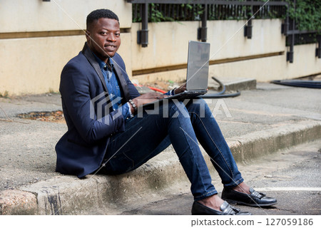 Businessman sat outside modern office block 127059186