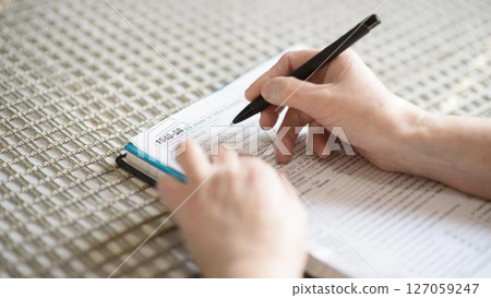 Senior Taxpayer Completing 1040-SR Income Tax Return Senior Taxpayer Completing 1040-SR Income Tax Return 127059247