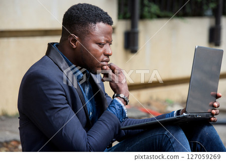 Businessman sat outside modern office block 127059269