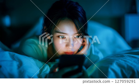 女人睡前查看智慧型手機的生活方式 女人睡前查看智慧型手機的生活方式 127059291