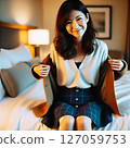 A woman sitting on a bed 127059753