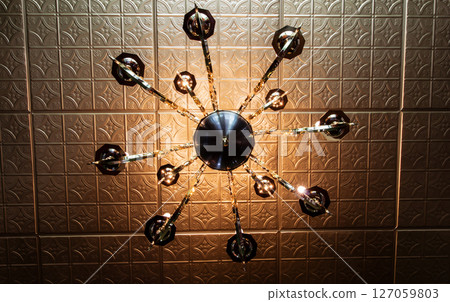 Looking Up at a Light Fixture That is Underneath a Tin Ceiling 127059803