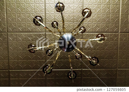 Looking Up at a Light Fixture That is Underneath a Tin Ceiling 127059805