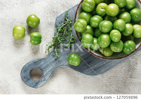 Tkemali, green cherry plum, in a bowl, on a gray table, top view, natural light, no people, 127059896