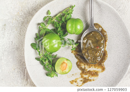 a spoon with tkemali sauce, on a plate, with cherry plum and mint, top view, no people, a spoon with tkemali sauce, on a plate, with cherry plum and mint, top view, no people, 127059903