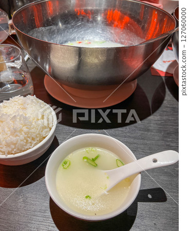 Boiled rice and soup in a bowl on the table Boiled rice and soup in a bowl on the table 127060000