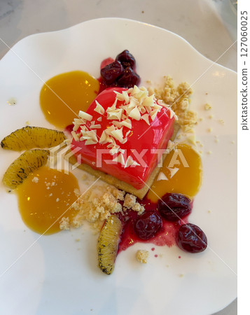 Dessert with fruit and berries on a white plate in a restaurant 127060025