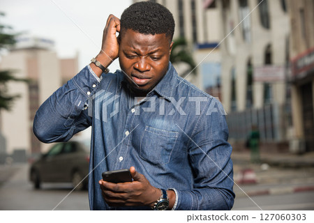 portrait of young african man with mobile phone. 127060303