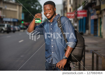 young traveler showing a credit card outside 127060464