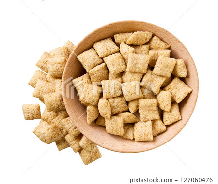 corn pillows pouring out of wooden bowl isolated on white background. Top view. corn pillows pouring out of wooden bowl isolated on white background. Top view. 127060476