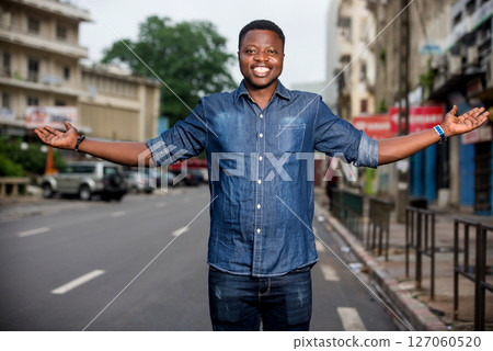 young happy man making welcome gesture on the street 127060520