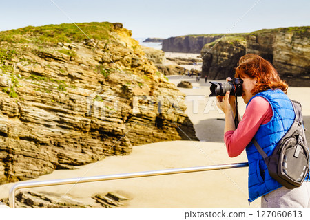 Woman with camera at Cathedral Beach in Spain. Woman with camera at Cathedral Beach in Spain. 127060613