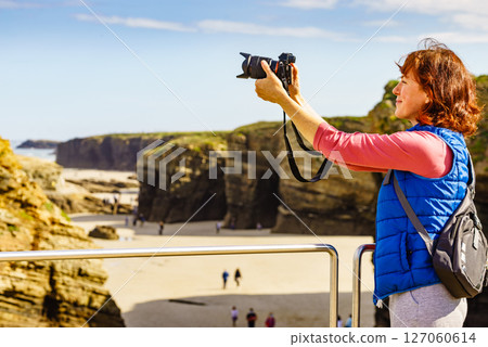 Woman with camera at Cathedral Beach in Spain. Woman with camera at Cathedral Beach in Spain. 127060614