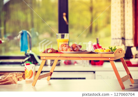 Breakfast on little table, orange juice croissant 127060704