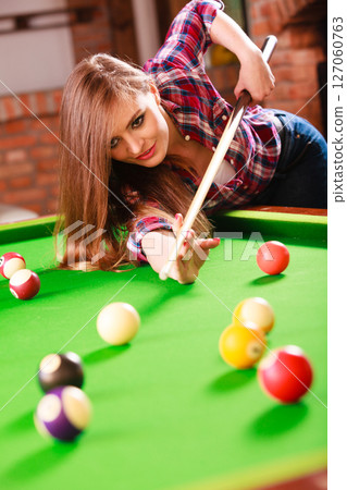 Young woman having fun with billiard. 127060763