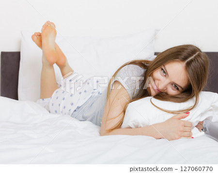 Cheerful girl rolling in bed. 127060770