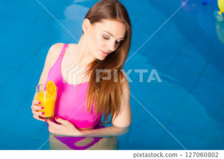 Girl relaxing at swimming pool with drink 127060802