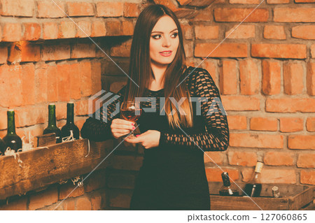 Woman tasting wine in rural cottage interior Woman tasting wine in rural cottage interior 127060865