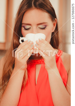 Pretty woman drinking tea or coffee at home. Pretty woman drinking tea or coffee at home. 127060875