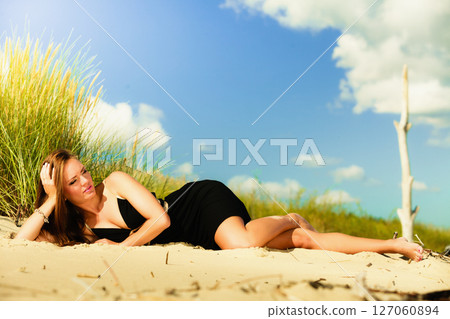 Woman sunbathing on beach. 127060894