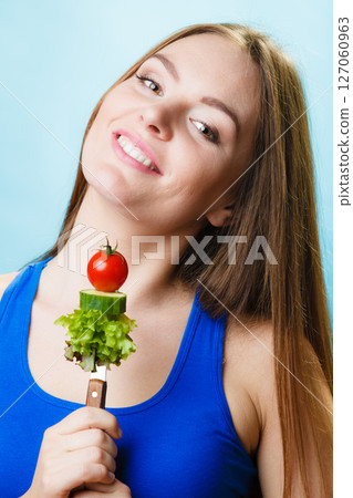 Vegetarian girl holding stack of vegetables. Vegetarian girl holding stack of vegetables. 127060963